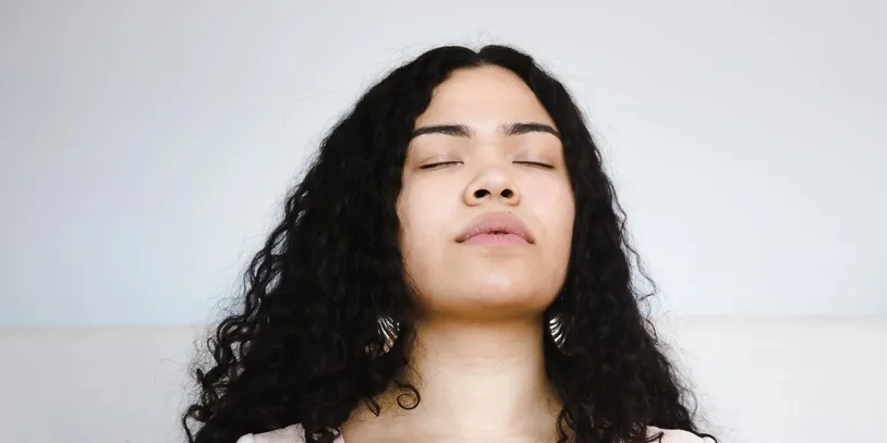 rs=w_814,h_407,cg_true A woman with long hair is meditating.